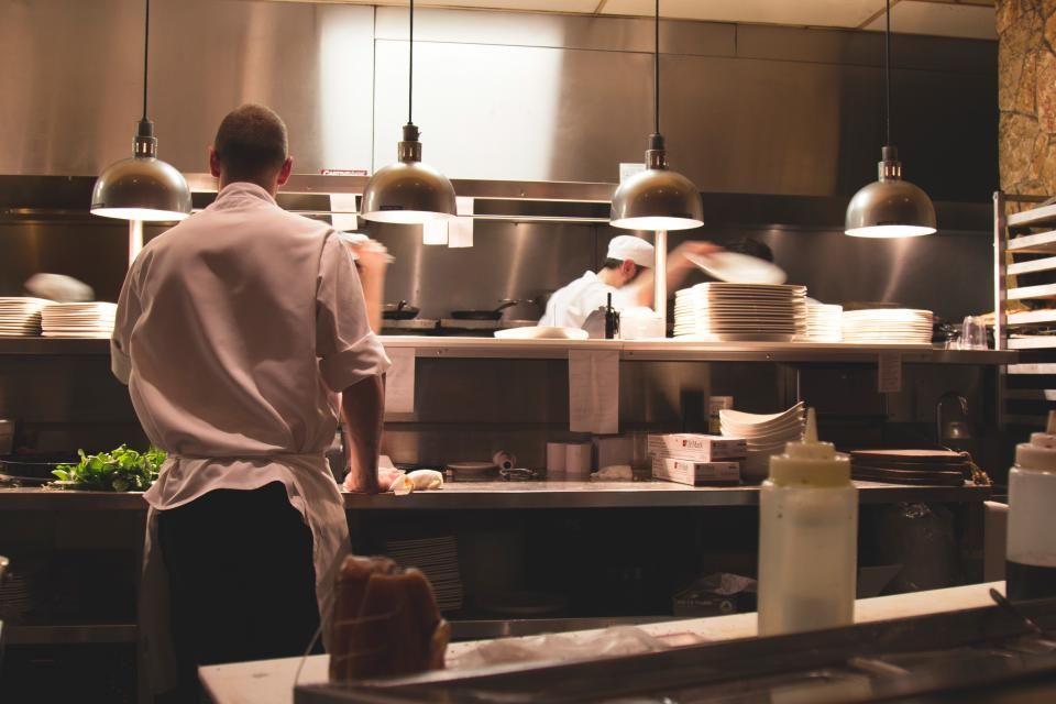 Cuisine commerciale en service : comptoirs en acier inoxydable sous les hottes